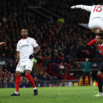 Sevilla's Moroccan forward Youssef En-Nesyri headers ball to score a second goal, deflected in for an own goal off Manchester United's English defender Harry Maguire (L) during their UEFA Europa league quarterfinal first leg at Old Trafford stadium on Thursday. (AFP)