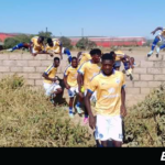   Aguila Stars FC players jump over a wall fence to avoid the stadium's main gate.