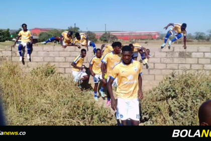  Aguila Stars FC players jump over a wall fence to avoid the stadium's main gate.