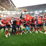 Luton Town FC players celebrating their promotion to the Premier League.