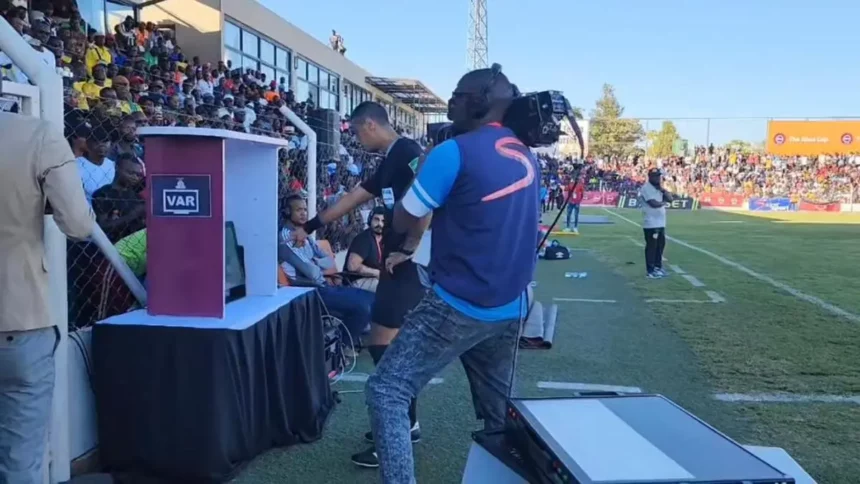 Egyptian referee Amin Omer consulting the Video Assistant Referee (VAR) during the 2023 ABSA Cup final between Forest Rangers and FC Muza at Lusaka's Woodlands Stadium.