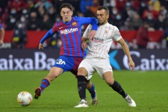 Barcelona's Spanish midfielder Gavi (L) is challenged by Sevilla's Spanish midfielder Joan Jordan Moreno during the Spanish league football match between Sevilla FC and FC Barcelona at the Ramon Sanchez Pizjuan stadium in Seville on December 21, 2021. (Photo by CRISTINA QUICLER / AFP) (Photo by CRISTINA QUICLER/AFP via Getty Images)