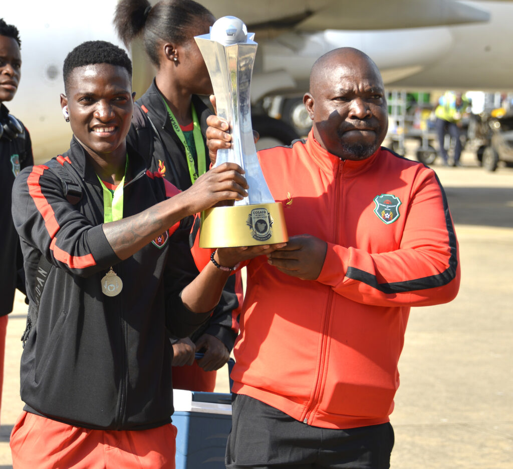 Striker Temwa Chawinga and Lovemore Fazili with the Cosafa trophy at the Chileka Airport on arrival from South Africa.(Photo/courtesy)