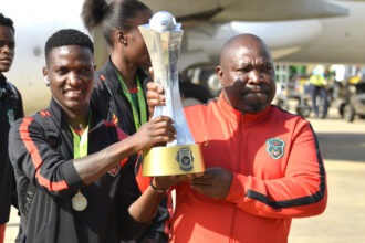 Striker Temwa Chawinga and Lovemore Fazili with the Cosafa trophy at the Chileka Airport on arrival from South Africa.(Photo/courtesy)