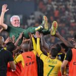 South Africa's head coach Hugo Broos celebrates with his players after they won the Africa Cup of Nations (CAN) 2024 third place play-off against DR Congo at Felix Houphouet-Boigny Stadium in Abidjan on February 10, 2024. (Photo by Sia KAMBOU / AFP)