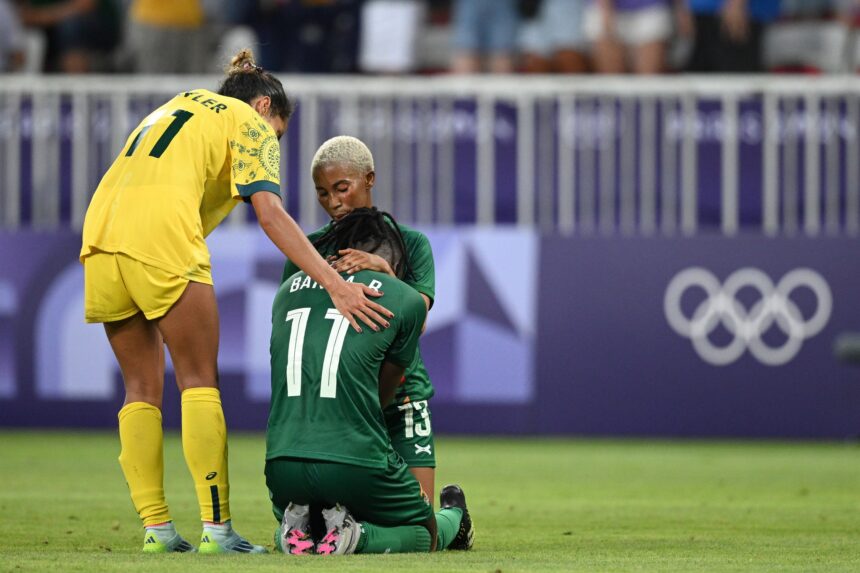 Barbra Banda #11 of Team Zambia is consoled by teammate Martha Tembo #13 and Mary Fowler #11 of Team Australia following a loss in the Women's group B match between Australia and Zambia during the Olympic Games Paris 2024 at Stade de Nice on July 28, 2024 in Nice, France. (Photo by Stuart Franklin - FIFA/FIFA via Getty Images)