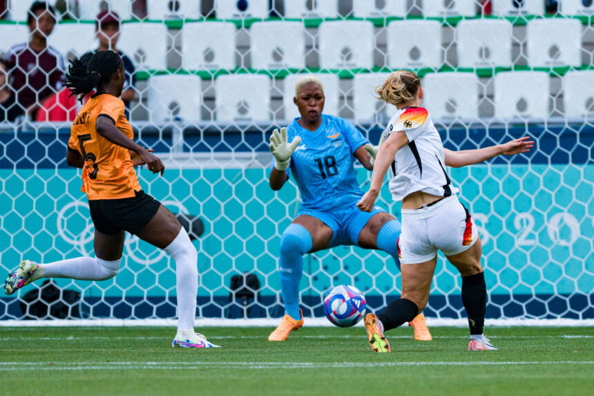 Lea Schueller of Germany (R) attempts a kick for score her goal over Goalkeeper Ngambo Musole of Zambia (C) during the Women's group B match between Zambia and Germany during the Olympic Games Paris 2024 at Stade Geoffroy-Guichard on July 31, 2024 in Saint-Etienne, France. (Photo by Eurasia Sport Images/Getty Images)